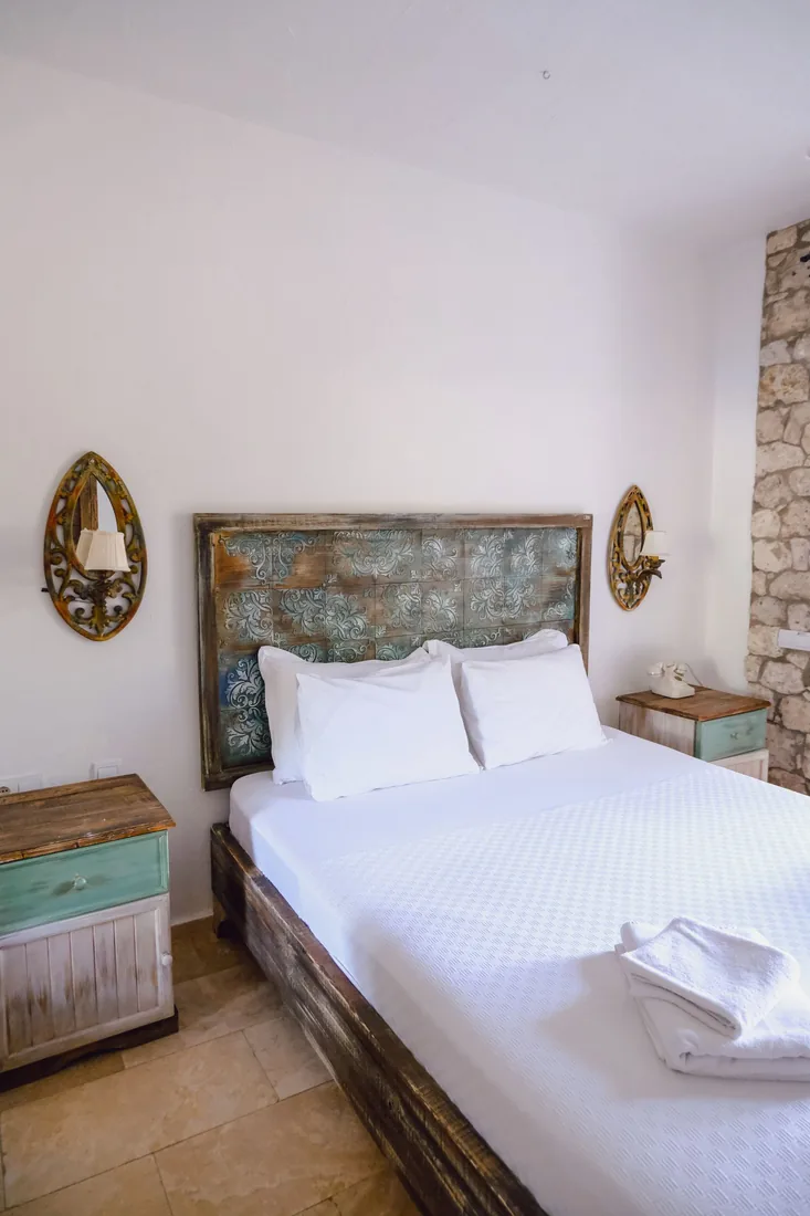 Queen-size bed with white bedding in a compact bedroom